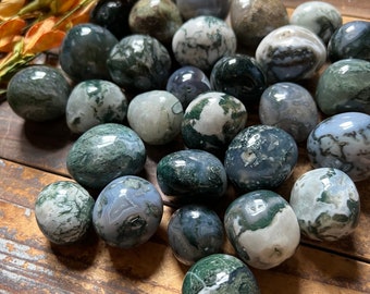 Pode incluir: Uma coleção de pedras de ágata musgosa polidas em vários tons de verde, branco e cinza. As pedras são lisas e polidas, com um visual natural e orgânico.