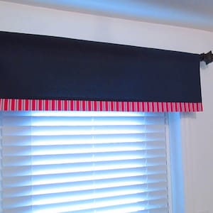 K&ouml;nnte beinhalten: Ein marineblauer Volant mit einem rot-wei&szlig; gestreiften Saum. Der Volant ist an einem wei&szlig;en Fenster mit wei&szlig;en Jalousien angebracht.