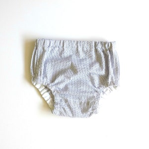 May include: White and blue striped baby bloomers with a white elastic waistband.