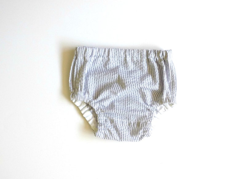 May include: White and blue striped baby bloomers with a white elastic waistband.