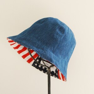 May include: A blue denim bucket hat with a red, white, and blue American flag print on the inside.