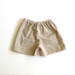 May include: A pair of beige linen shorts with an elastic waistband.