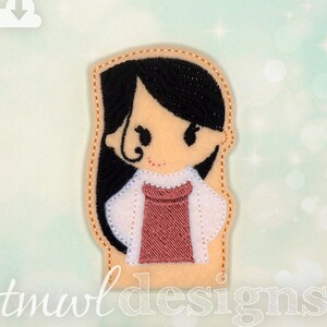 May include: A felt applique of a girl with long black hair, wearing a white shirt and a pink dress. The applique is outlined in orange thread.