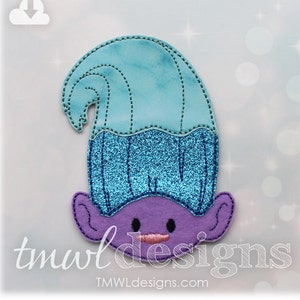 May include: A blue and purple felt appliqué of a troll with a blue glittery hair. The troll has a purple face with black eyes and a pink mouth.