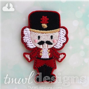 Puede incluir: Una aplicación de fieltro rojo y blanco de un cascanueces con un sombrero negro y un ribete dorado. El cascanueces tiene una barba blanca, un bigote negro y un uniforme rojo y blanco.