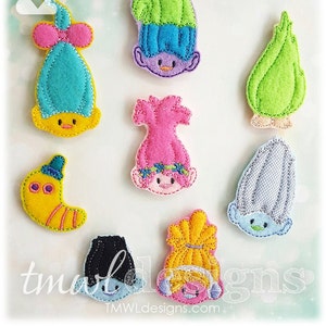 May include: Set of nine felt appliques featuring various troll characters. The appliques are in various colors, including blue, green, pink, yellow, and gray. Each applique has a unique design and expression.