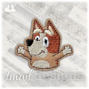 May include: Embroidered patch of a brown and white dog with a red patch on its head. The dog is smiling and has its arms outstretched.