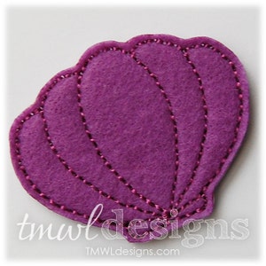 May include: A purple felt seashell with a stitched design. The seashell is a popular craft supply for making jewelry, hair accessories, and other crafts.