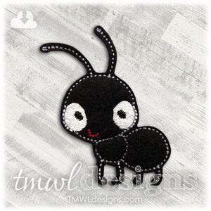 May include: A black ant-shaped applique with white embroidered details and a red smile. The applique has two curved antennae and is stitched with white thread. The text "tmwl designs" and "tmwldesigns.com" is visible.