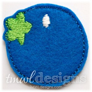 May include: Blue felt appliqué of a blueberry with a green leaf. The blueberry is outlined in dark blue thread.