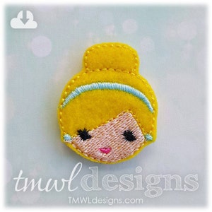 May include: A felt appliqu&eacute; of a cartoon princess with blonde hair, a blue headband, and a pink face. The appliqu&eacute; is yellow and has embroidered details.