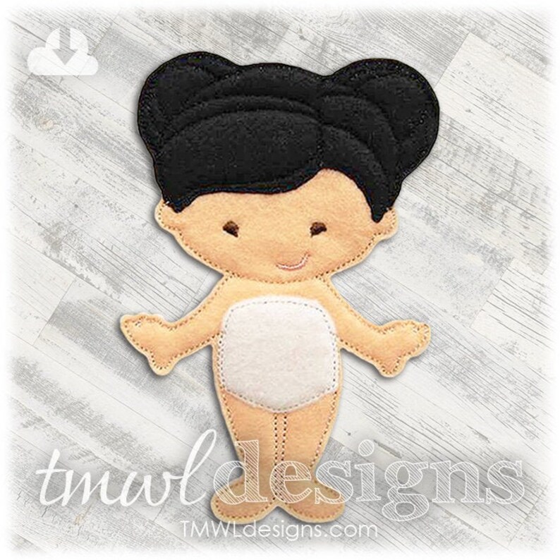 May include: A felt doll with black hair, a white dress, and a light brown body. The doll is standing on a white wooden surface.