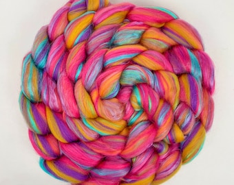 May include: A colorful ball of yarn with pink, purple, yellow, and blue stripes. The yarn is arranged in a spiral pattern.