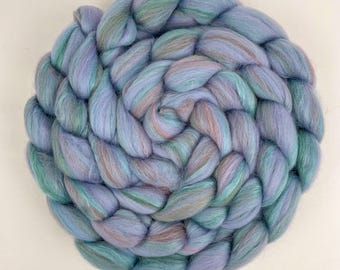 May include: A braided ball of yarn in shades of lavender, teal, and pink. The yarn is soft and fluffy, perfect for knitting or crocheting.