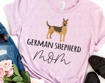 May include: A pink t-shirt with a German Shepherd silhouette and the text "German Shepherd Mom" in black lettering.