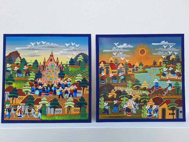 May include: Two colorful paintings depicting scenes of rural life in a village. The first painting shows a church with a pink facade and a crowd of people in front of it. The second painting shows a village with houses, a river, and people working in the fields.
