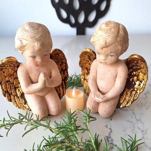 May include: A white ceramic mug with a black handle and the text "But First, Coffee" in a bold, black font. The mug is set against a blurred background, suggesting a cozy setting.