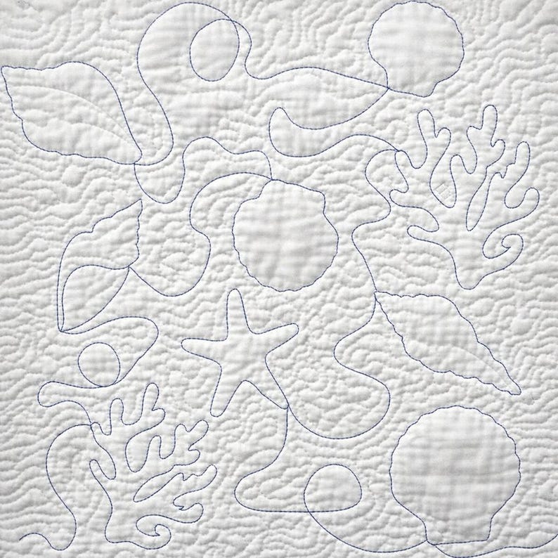 May include: edge to edge quilt design. A white quilt with a sea life design. The quilt features blue stitching that outlines various sea creatures, including seashells, starfish, and coral. The background has a textured, wavy pattern.