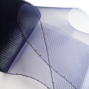 May include: A roll of navy blue tulle fabric with a slightly textured surface. The tulle is soft and sheer, with a delicate, slightly ruffled edge.