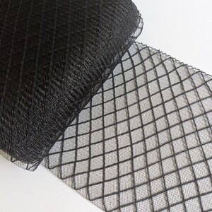 May include: Black mesh ribbon with a diamond pattern. The ribbon is rolled up and the mesh is visible.
