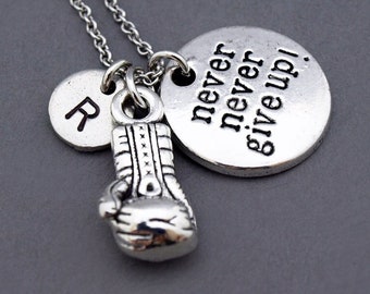 Könnte beinhalten: Silberne Halskette mit einem Boxhandschuh-Anhänger, einem runden Anhänger mit dem Text "never never give up!" und einem runden Anhänger mit dem Buchstaben "R".