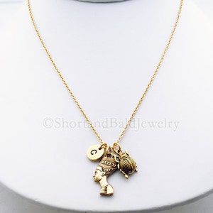 K&ouml;nnte beinhalten: Goldkette mit einem Anh&auml;nger einer &auml;gyptischen K&ouml;nigin, einem Skarab&auml;us und einem Buchstaben 'C' Anh&auml;nger.
