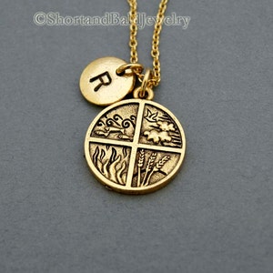 May include: Gold necklace with a round pendant featuring four elements: water, air, fire, and earth. The pendant is attached to a gold chain with a smaller round charm with the letter "R" on it.