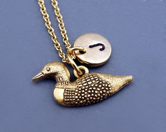 Könnte beinhalten: Goldkette mit einem Loon-Anhänger und einem goldenen Initialen-Anhänger. Der Initialen-Anhänger trägt den Buchstaben "J".