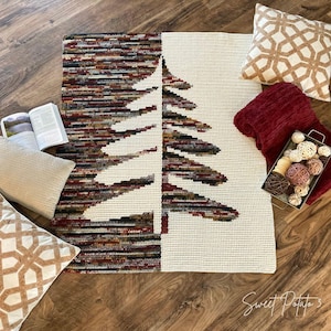 Peut inclure: Un tapis décoratif avec un motif d'arbre, présentant un motif moitié-moitié. Un côté a un motif texturé multicolore, tandis que l'autre est de couleur crème avec un contour d'arbre. L'image comprend également des coussins, un plaid et des objets décoratifs.