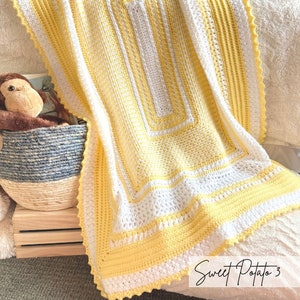 May include: A yellow and white crocheted baby blanket with a scalloped edge. The blanket has a large square pattern in the center and a border of alternating yellow and white stripes. The text "Sweet Potato 3" is written in cursive on the bottom right corner of the blanket.