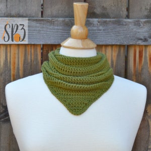 Peut inclure: Un chauffe-cou ou une écharpe en crochet vert sur un mannequin blanc. Le chauffe-cou est de forme triangulaire et a une texture en crochet.