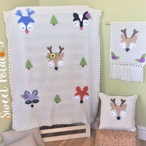 May include: A set of crocheted woodland animal themed home decor items. The set includes a blanket, a pillow, and a wall hanging. The blanket features a blue owl, a black and white skunk, a deer, a raccoon, and a fox. The pillow features a deer. The wall hanging features a deer with a floral design. All items are crocheted in a cream color with colorful accents.