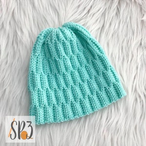 May include: A light blue crocheted beanie with a textured stitch pattern.