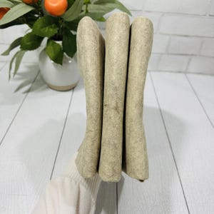 May include: Three pieces of beige felt fabric stacked together.