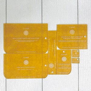 May include: A set of nine yellow fabric pattern pieces for sewing a bag. The pieces are labeled with letters and include instructions for cutting the fabric. The pieces are labeled: Piece A, Piece B, Piece C, Piece D, Piece E, Piece F, Piece G.