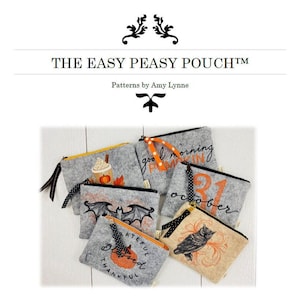 May include: A collection of gray felt zipper pouches featuring embroidered designs including a pumpkin spice drink, a bat, an owl, the text "good morning pumpkin", and "31 october". Each pouch has a decorative ribbon pull on the zipper.