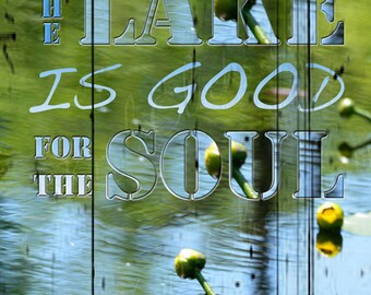 May include: A rustic wooden sign with the text "THE LAKE IS GOOD FOR THE SOUL" in a blue and white font. The sign is blurred and overlaid with a green and blue image of a lake with lily pads.