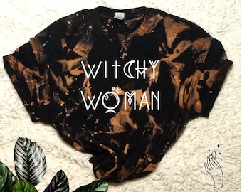 May include: Black tie-dye t-shirt with the text "Witchy Woman" in white. The shirt has a distressed look and is a great choice for a witchy wardrobe.