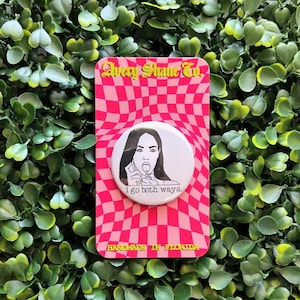 May include: White button with a black and white line drawing of a woman with a lollipop in her mouth. The button has the text "I go both ways." and is on a pink and white checkered background with the text "Avery Shame Co." and "Handmade in Florida."