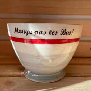 Bol à café avec inscription « Mange pas tes bas » motif imitation des bas de laine gris avec bordure rouge.