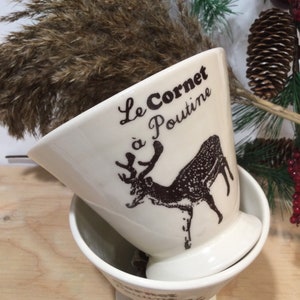 Może przedstawiać: Dwie białe ceramiczne miski z brązowym wzorem jelenia i tekstem "Le Cornet à Poutine".