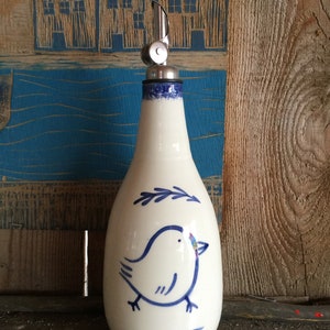 De olie- of azijnfles wit met een blauwe vogel en mooie schenktuit