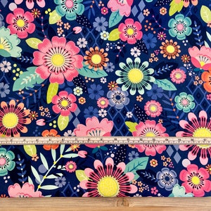 May include: A navy blue fabric with a floral pattern featuring pink, yellow, and green flowers. The fabric has a repeating pattern of flowers and leaves. The fabric is measured with a ruler.
