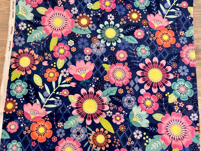 May include: A navy blue fabric with a floral pattern. The flowers are pink, orange, yellow, and green. The fabric has a geometric pattern in the background.