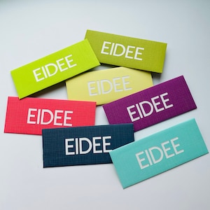 May include: A collection of rectangular cards in various colors, including green, red, purple, and blue. Each card features the word "EIDEE" in white, centered on the front. The cards have a textured surface.