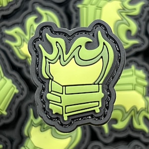 May include: A green and black patch with a stylized image of a burning dumpster. The dumpster is outlined in black and has a flame design above it.