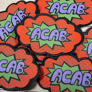 May include: Five iron-on patches with a comic book style design. Each patch features the acronym "ACAB" in purple letters on a green background with a red and white dotted border.