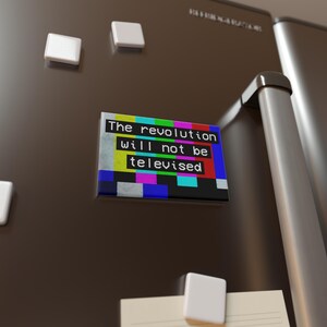 May include: A refrigerator magnet with a colorful TV test pattern background and the text "The revolution will not be televised".