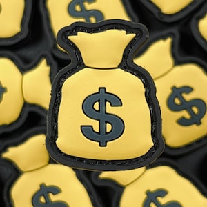 May include: A close-up of a gold money bag patch with a black dollar sign. The patch is surrounded by other similar patches.