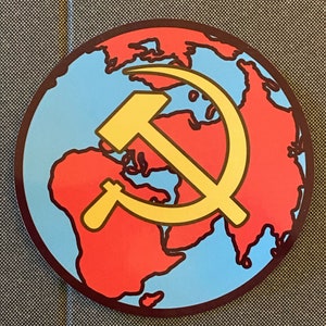 May include: A red, white, and blue globe with a yellow hammer and sickle symbol on top. The globe is surrounded by a brown circle.